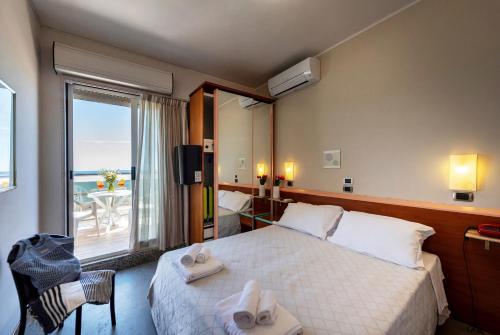 a hotel room with a bed and a large window at Hotel Soraya in San Benedetto del Tronto