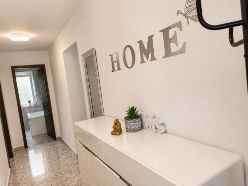 a white room with a home sign on the wall at Móra Apartman in Pécs