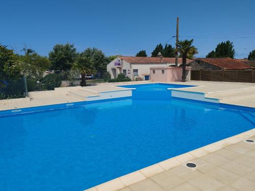 a large blue swimming pool in a yard at Camping de la Rive in Notre-Dame-de-Monts