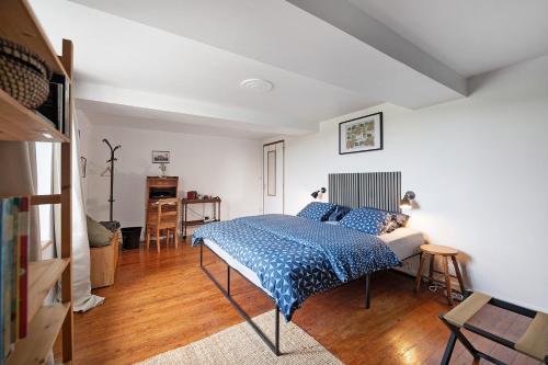 a bedroom with a blue bed in a room at La Bourgerie in Saint-Aubin-des-Bois