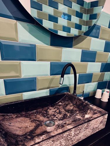 a sink in a kitchen with blue and white tiles at Hôtel du Golfe Pinarello in Pinarellu