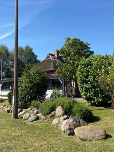 a house with a bunch of rocks in the yard at Ferienwohnung Sternenhimmel in Dranske