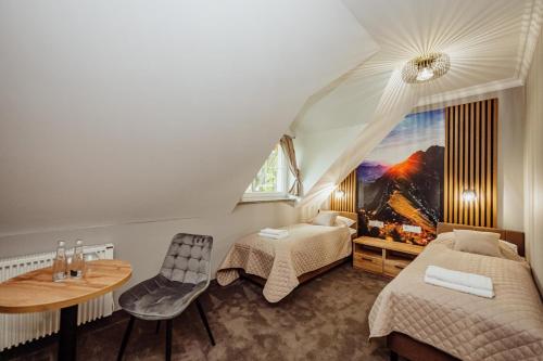 ein Schlafzimmer mit zwei Betten, einem Tisch und einem Fenster in der Unterkunft Lekkoduch in Świeradów-Zdrój