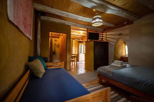 a bedroom with two beds and a living room at Sons do Eo- Apartamentos rurales sostenibles en Baleira Lugo in Baleira