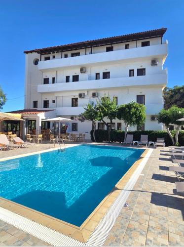 ein Hotel mit einem Schwimmbad vor einem Gebäude in der Unterkunft Archontiko Hotel in Ammoudara