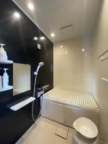 a bathroom with a shower and a toilet in it at コハクサカイミナト in Sakaiminato