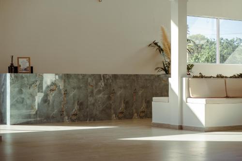 a white room with a potted plant on a wall at Golden Coast Beachfront Resort in Kypseli