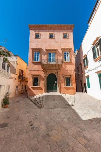 a large brick building with a balcony in a courtyard at Palazzo Venneri Lloyd - Historic Heritage Palazzo in Gallipoli
