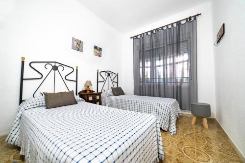 a bedroom with two beds and a window at Villa Mª José in Benicarló