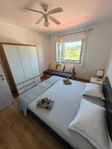 a large bed in a bedroom with a ceiling fan at Apartment Miljenko Tomić in Splitska