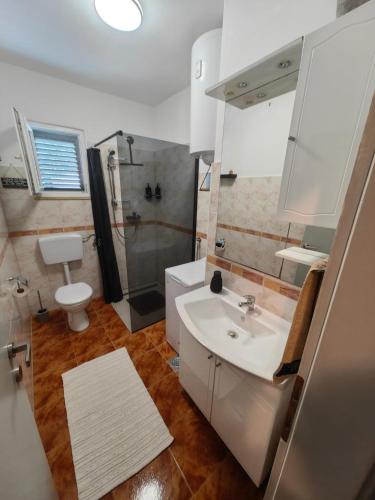 a bathroom with a sink and a shower and a toilet at Apartment Miljenko Tomić in Splitska