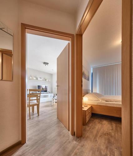 a bedroom with a bed and a dining room at Elbe I, Ferienwohnung 29 in Cuxhaven