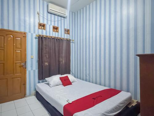 a bedroom with a bed with a red towel on it at RedDoorz at Kuning GH Jatinangor in Sayang