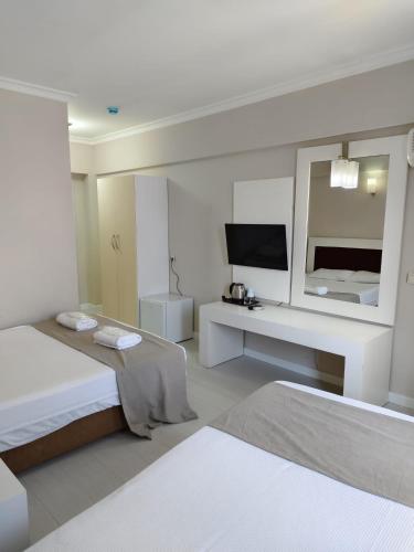 a white room with two beds and a mirror at Halıcı Hotel Resort & SPA in Pamukkale