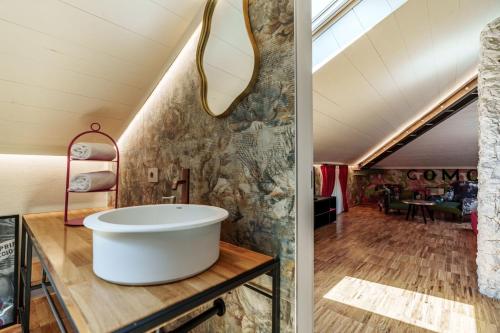 a bathroom with a large tub on a table in a attic at Aurum Collection - Como Suites in Como