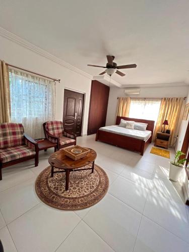 a living room with a bed and a table at Nortram Homes - Adenta in Apenkwa