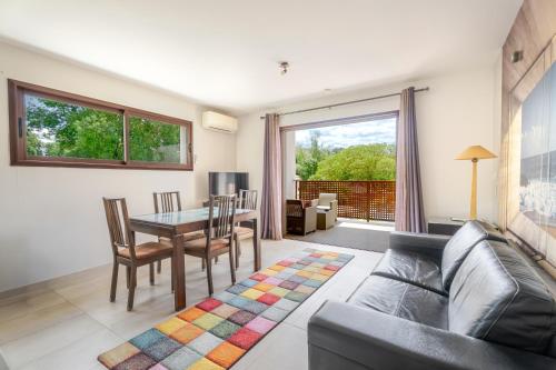 a living room with a couch and a table and chairs at Les Terrasses in Lavérune