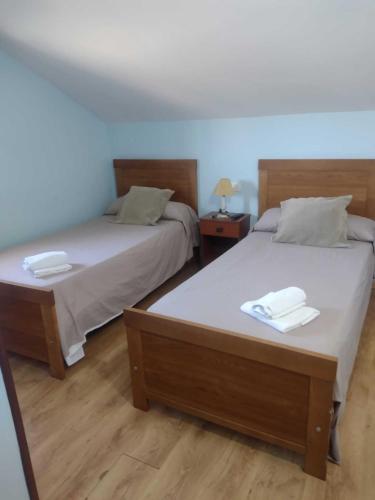 two beds sitting next to each other in a room at Isa Rooms Sarria in Sarria