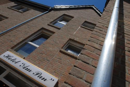 a brick building with a street sign in front of it at Hotel Am Pan in Emmerich