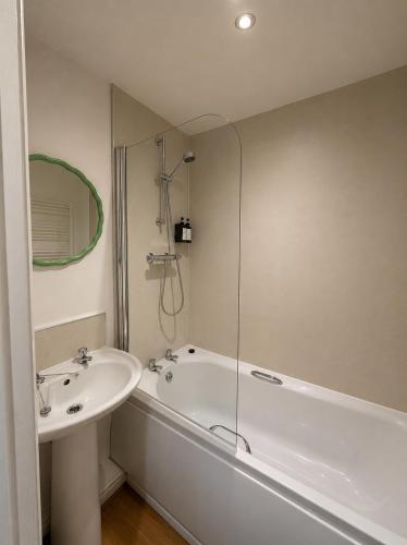 a bathroom with a sink and a bath tub and a mirror at Urban Perch in Penrith