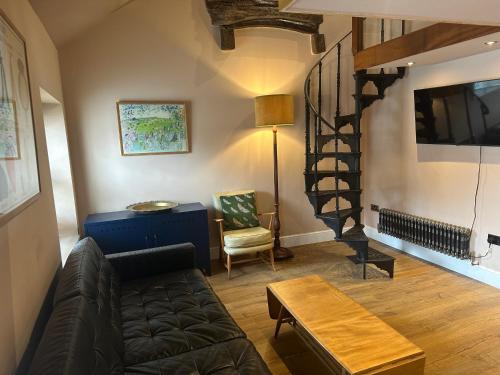 a living room with a couch and a stair case at Urban Perch in Penrith