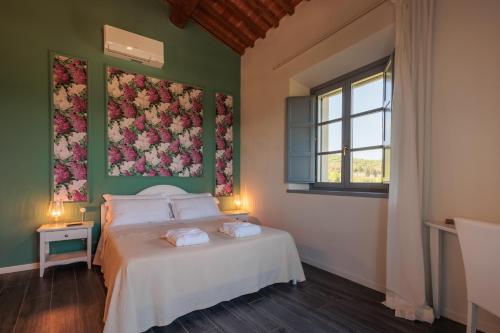 a bedroom with a bed with a floral painting on the wall at Podere La Doccia in Civitella in Val di Chiana