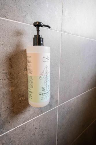 a bottle of soap sitting on a tile wall at Résidence Arya - Living Stone in Vars