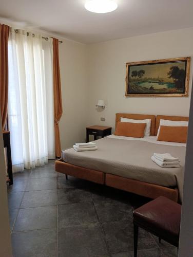 ein Schlafzimmer mit einem Bett und einem Gemälde an der Wand in der Unterkunft Hotel La Cavalera in Augusta