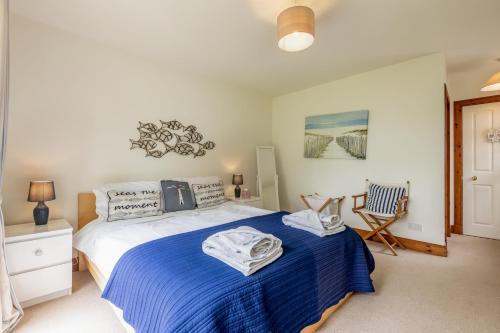 a bedroom with a bed and a chair in it at Stable Cottage - Elie in Elie