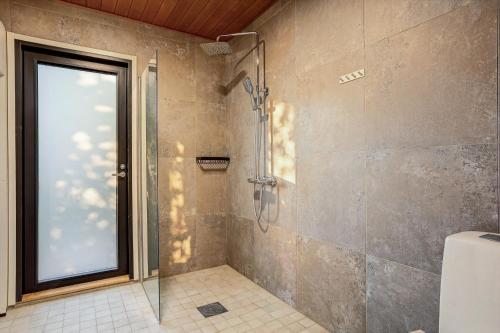a shower with a glass door in a bathroom at Villa Karina - Beachfront with Jacuzzi in Porvoo