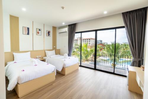 a hotel room with two beds and a large window at PP Garden Home in Sathani Lat Krabang