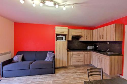 a living room with a couch and a kitchen at Studio 5 personnes au revard in Les Déserts
