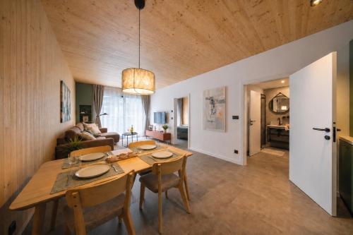 a dining room and living room with a table and chairs at Muhu Apartments in Velké Hamry