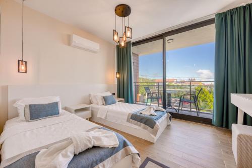 two beds in a room with a balcony at VILLA ALKIM in Kaş