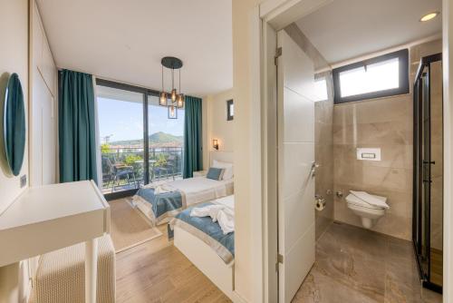 a hotel room with two beds and a bathroom at VILLA ALKIM in Kaş