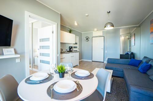 a living room with a table and a blue couch at Horyzont by Baltic Home in Międzyzdroje