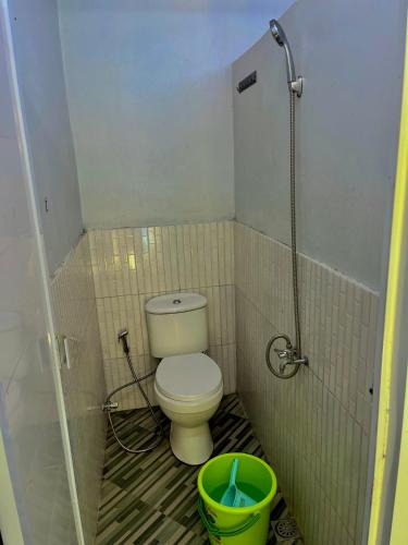 a small bathroom with a toilet and a bucket at Batupineus Riverside in Palayangan