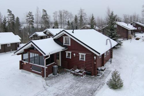 una vista aérea de una cabaña de madera en la nieve en Messilä Camping, en Hollola