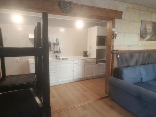 a living room with a couch and a kitchen at Escapade proche de l'estuaire in Valeyrac