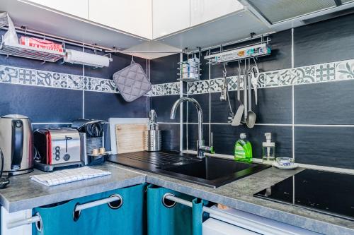 a kitchen with blue cabinets and a sink at Appartement Le Mauresque in Arcachon