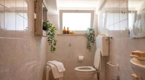 a bathroom with a toilet and a sink and a window at Brasilia Sweet Home in Cesenatico