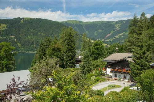 an aerial view of a house with a lake and mountains at Der Erlhof Restaurant & Landhotel in Zell am See