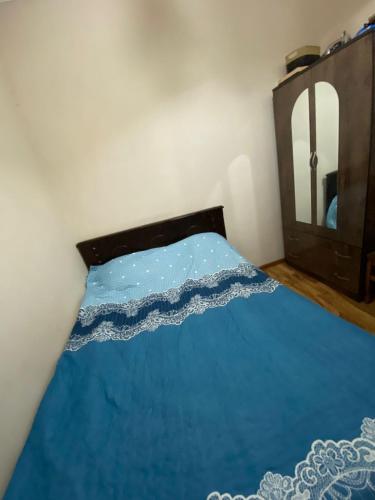 a bedroom with a blue bed with a mirror at batumi area in Angisa