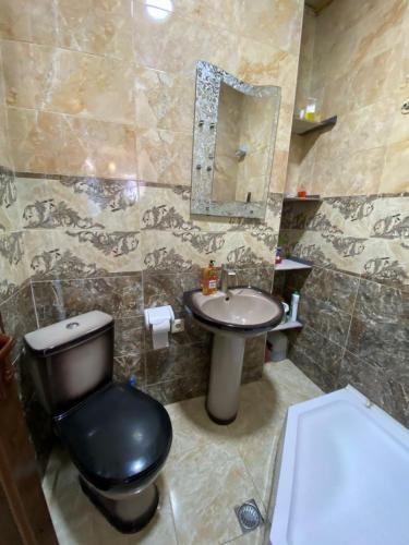 a bathroom with a black toilet and a sink at batumi area in Angisa