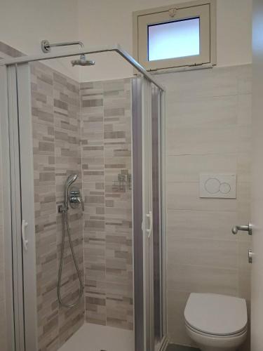a bathroom with a shower with a toilet and a window at Locri27 Apartment in Catanzaro Lido
