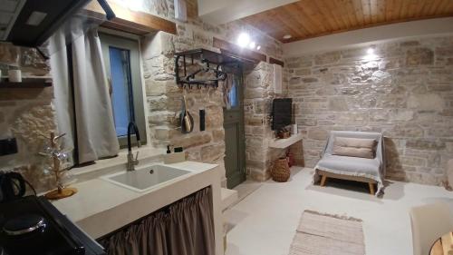 a bathroom with a sink and a chair at cozystudio Chezmoi in Chios