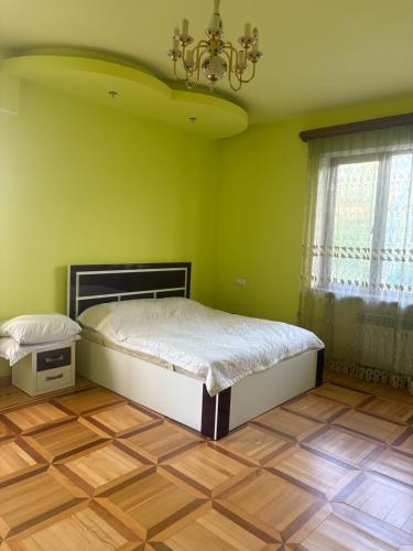 a bedroom with a bed in a green room at BEAUTI-House in Ijevan