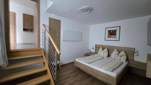a bedroom with a bed with pillows and a staircase at Ferienhaus Trift in Illmitz