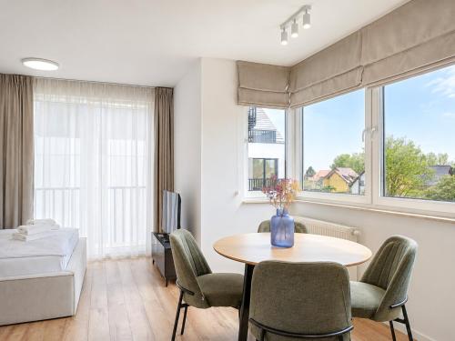 a room with a table and chairs and a bed at GRANO FLATS Sobieszewo - Baltic Line in Gdańsk