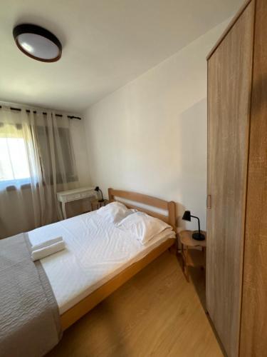 a bedroom with a white bed and a wooden door at Bar holiday apartment Kastro in Bar